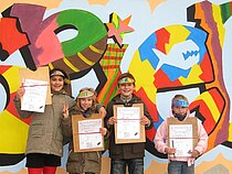 Vier Kinder zeigen stolz ihre Urkunden des Spielforsche-Workshops